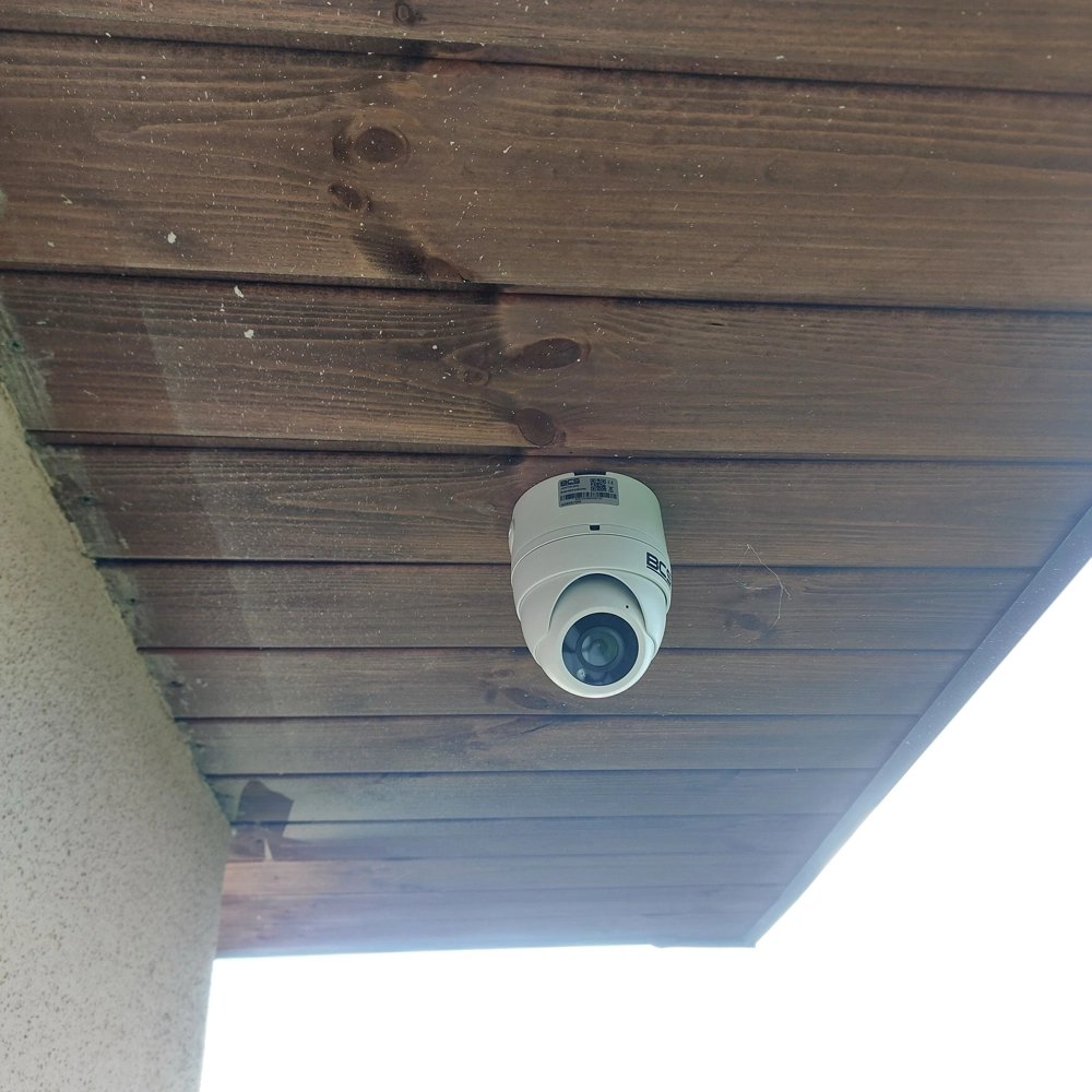 Kamera kopułkowa zamontowana pod drewnianym podsufitem – monitoring wizyjny